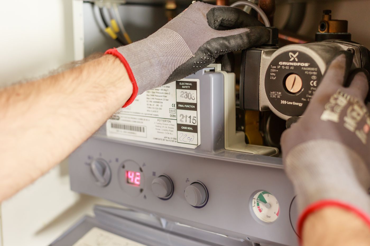 An engineer working on the internals of a domestic combi boiler.